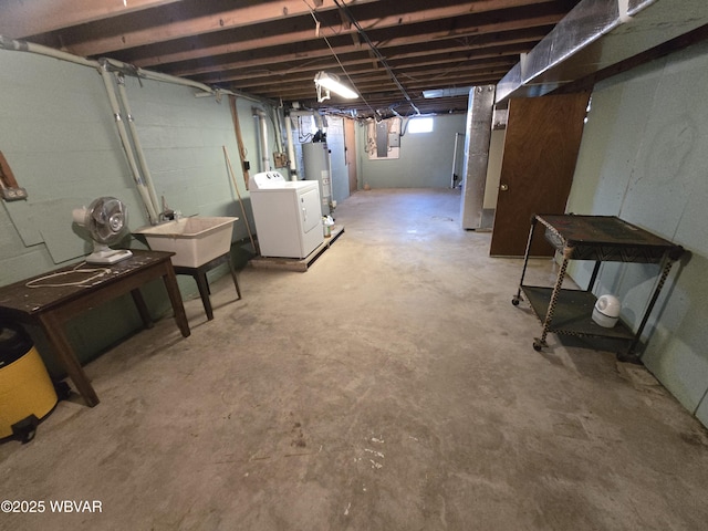 basement with water heater, washer / dryer, and a sink