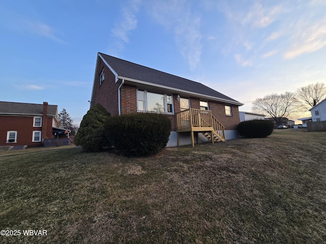 back of house featuring a yard and brick siding