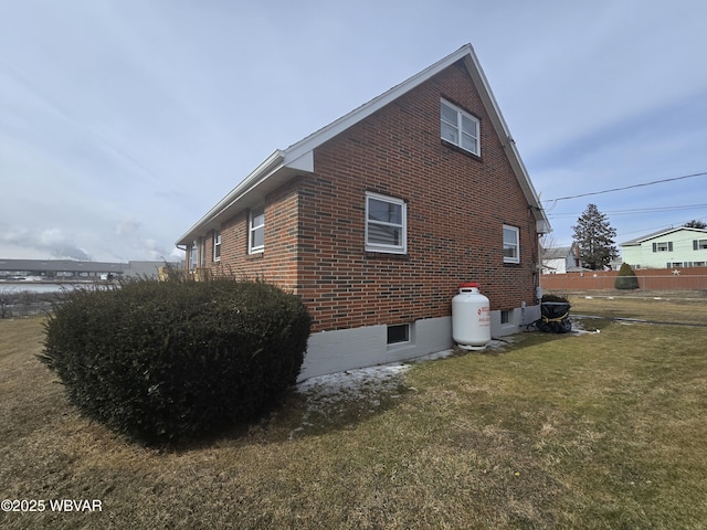 view of property exterior featuring a yard and brick siding