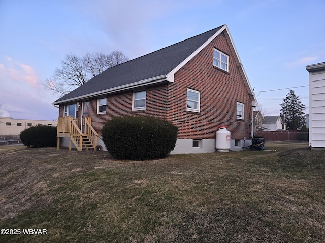 back of house featuring a yard and brick siding