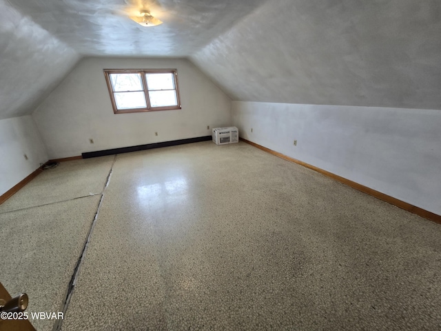 bonus room featuring lofted ceiling, baseboards, and a wall mounted AC