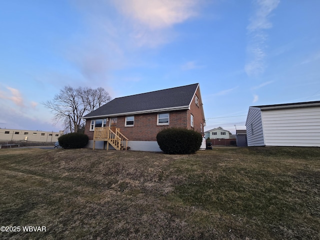 view of side of home with a yard and brick siding