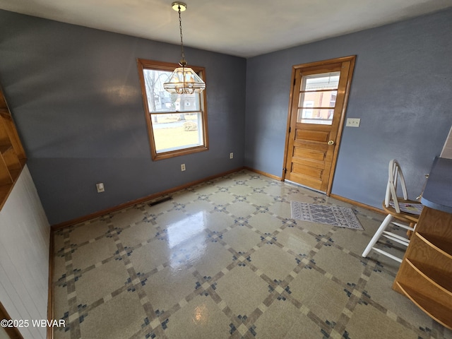 unfurnished dining area with tile patterned floors and baseboards