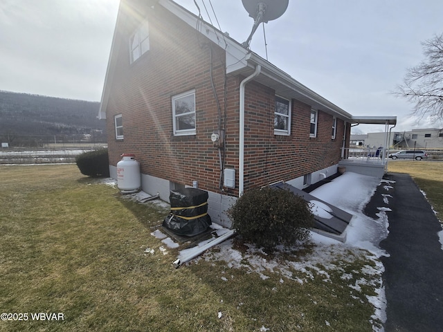 view of side of home with a yard and brick siding