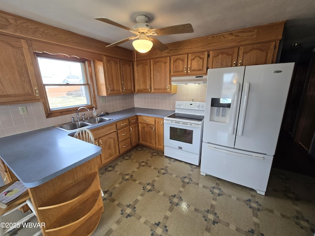 kitchen featuring under cabinet range hood, white appliances, brown cabinets, and a sink