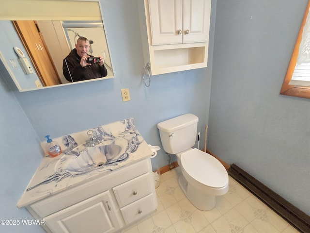 bathroom featuring baseboards, toilet, and vanity