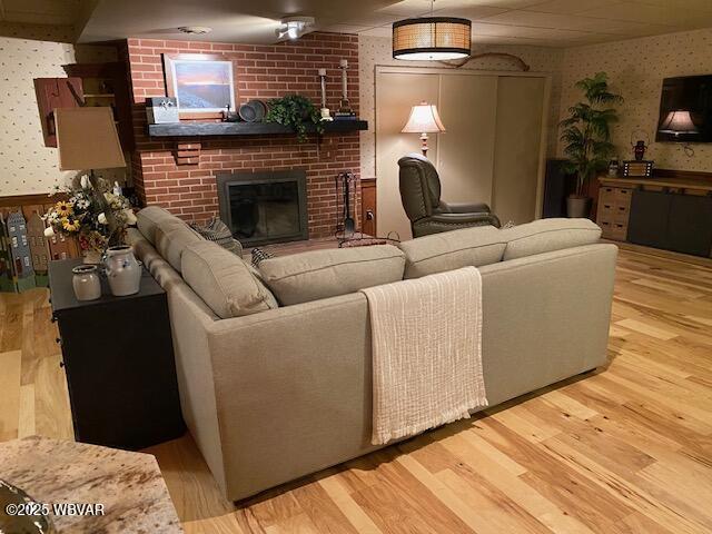 1550 Campbell St, Williamsport, PA 17701 - living area with a brick fireplace, wallpapered walls, and wood finished floors