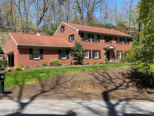 1550 Campbell St, Williamsport, PA 17701 - colonial home featuring brick siding, a front lawn, and a chimney
