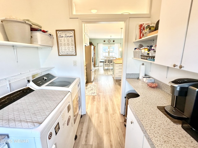 2035 Woodland Rd, Montoursville, PA 17754 - laundry room featuring washing machine and clothes dryer, light wood-style floors, and cabinet space