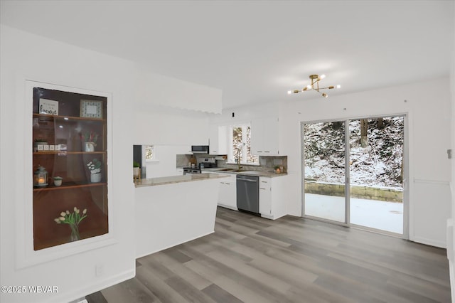 kitchen with appliances with stainless steel finishes, sink, white cabinetry, dark hardwood / wood-style floors, and a notable chandelier