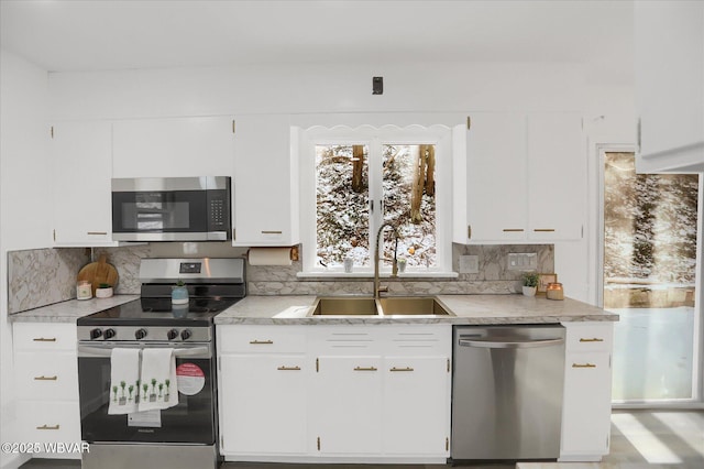 kitchen featuring sink, white cabinets, decorative backsplash, and stainless steel appliances