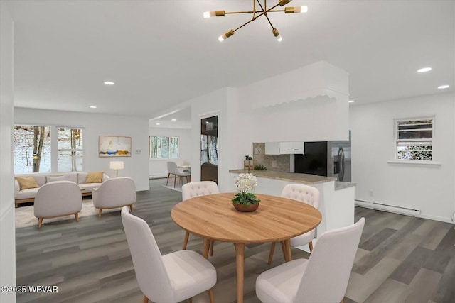 dining space featuring a baseboard radiator, dark hardwood / wood-style flooring, and a chandelier