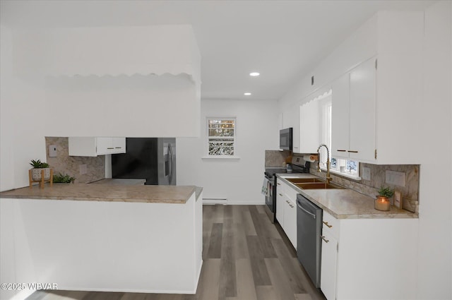 kitchen featuring wood-type flooring, sink, white cabinetry, decorative backsplash, and stainless steel appliances