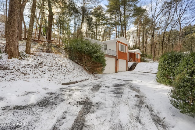 yard covered in snow featuring a garage