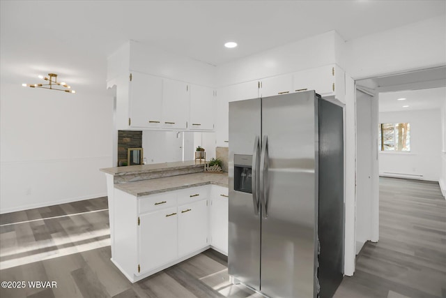 kitchen with kitchen peninsula, stainless steel refrigerator with ice dispenser, and white cabinets