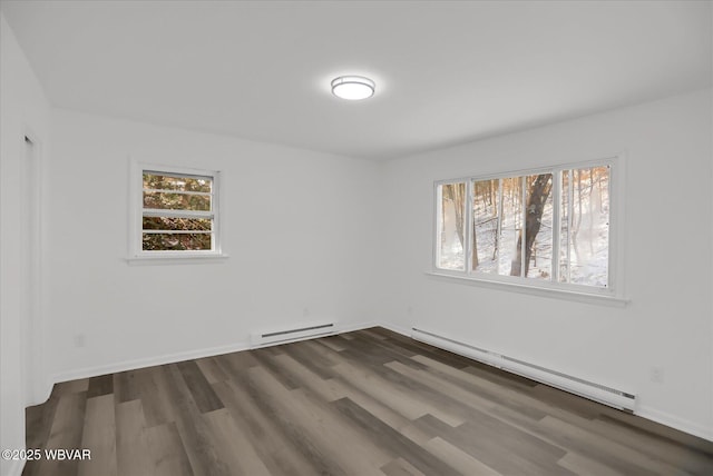 unfurnished room featuring a baseboard radiator and dark hardwood / wood-style flooring