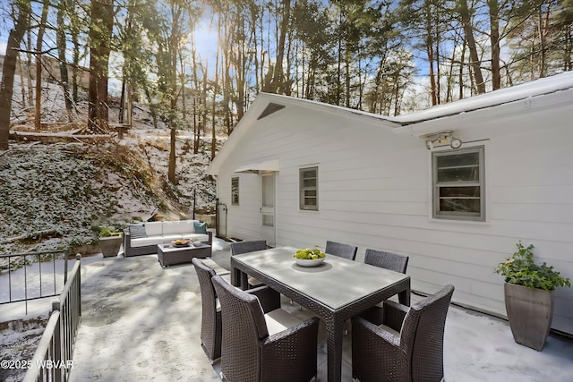 snow covered patio with an outdoor living space