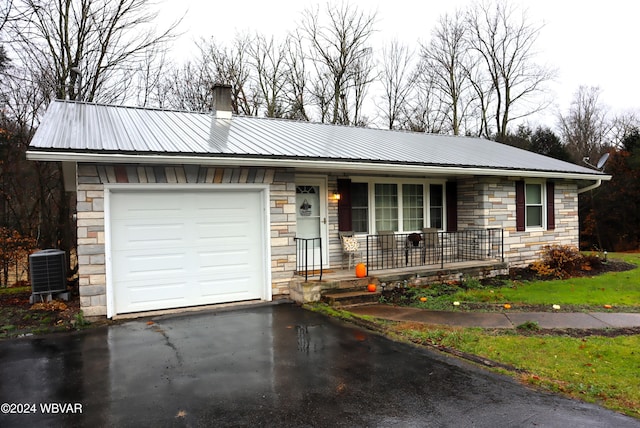 ranch-style house featuring a garage and central air condition unit