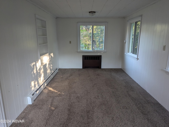 carpeted spare room featuring built in features, radiator, and a baseboard heating unit