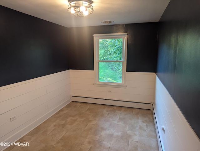 unfurnished room featuring a baseboard heating unit