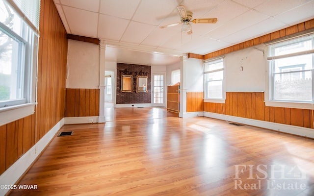 435 Grant St, Williamsport, PA 17701 - spare room with wood walls, ceiling fan, light wood-type flooring, and visible vents