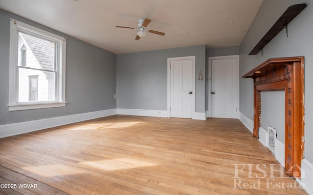 435 Grant St, Williamsport, PA 17701 - unfurnished living room with light wood-type flooring, ceiling fan, and baseboards