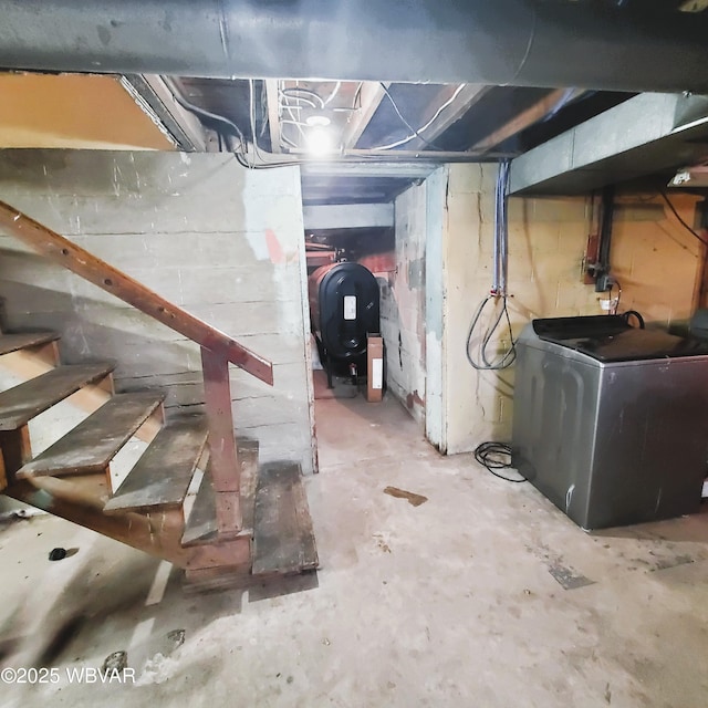 unfinished basement with stairway, washer / clothes dryer, and heating fuel