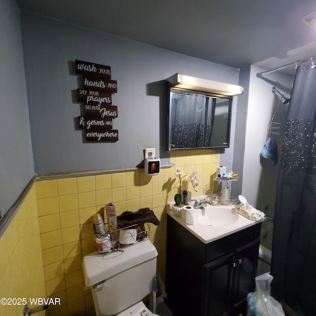 bathroom with tile walls, a shower with curtain, vanity, and toilet