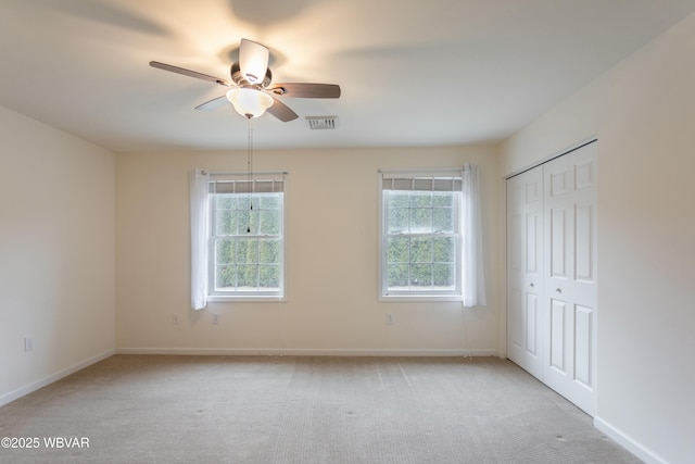 empty room with ceiling fan and light colored carpet