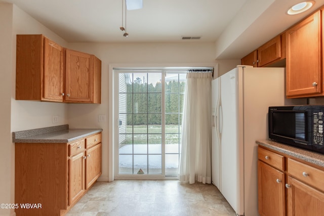 kitchen featuring white refrigerator with ice dispenser