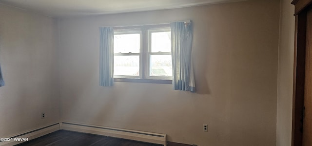 spare room featuring dark hardwood / wood-style floors and a baseboard radiator