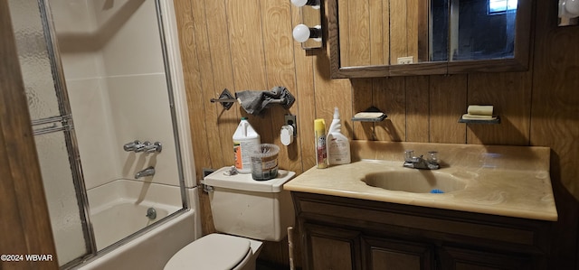 full bathroom featuring vanity, enclosed tub / shower combo, toilet, and wood walls