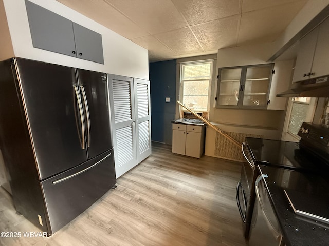 kitchen featuring fridge, black electric range, and light wood-type flooring