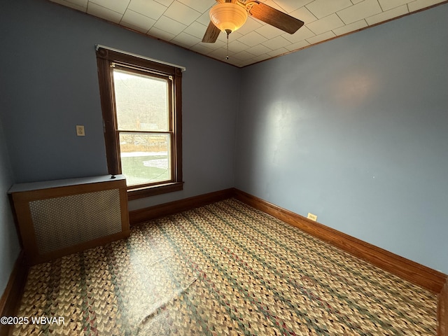 spare room with radiator and ceiling fan