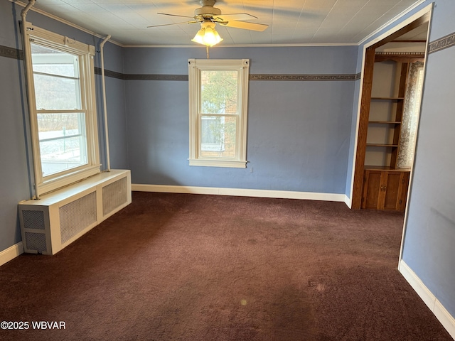 carpeted spare room featuring plenty of natural light, radiator, and ceiling fan