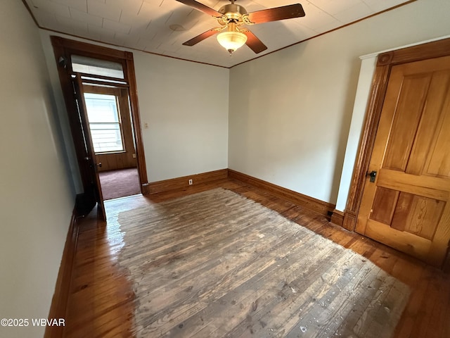 empty room featuring dark wood-type flooring and ceiling fan