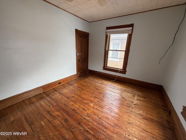 empty room featuring hardwood / wood-style flooring and crown molding