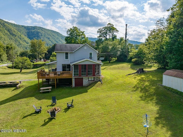 229 River Rd, Renovo, PA 17764 - back of property featuring a sunroom, a deck with mountain view, and a lawn