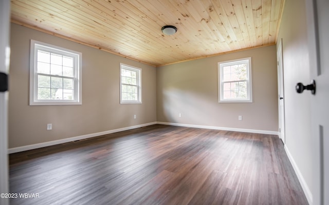spare room with baseboards, wooden ceiling, ornamental molding, and dark wood-type flooring