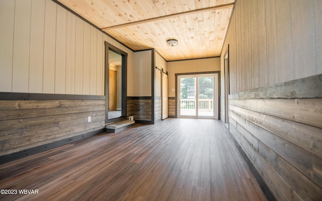 unfurnished living room featuring wood walls, wood finished floors, and wooden ceiling