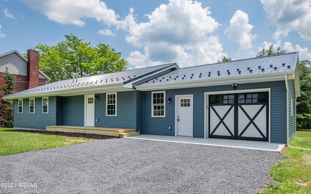 ranch-style home featuring a porch, driveway, and metal roof