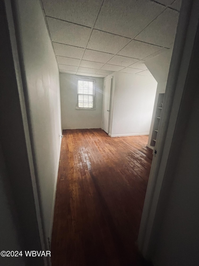 basement with a drop ceiling and hardwood / wood-style flooring