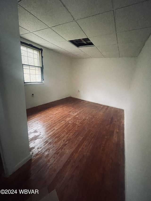 empty room with hardwood / wood-style floors and a paneled ceiling