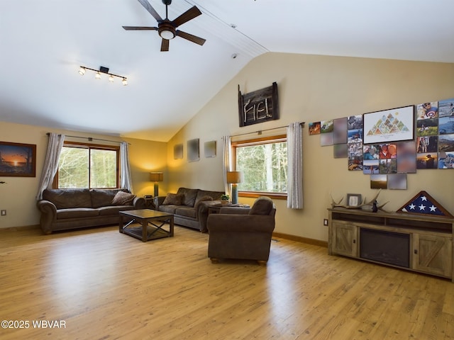 living room with lofted ceiling, light hardwood / wood-style flooring, and plenty of natural light