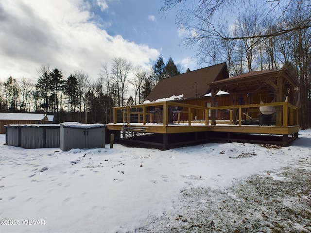 snow covered property featuring a hot tub and a deck