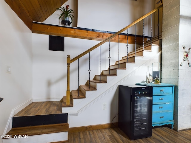 staircase with hardwood / wood-style flooring and beverage cooler