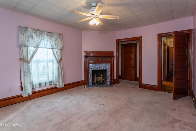 unfurnished living room featuring ceiling fan, light colored carpet, and a tile fireplace