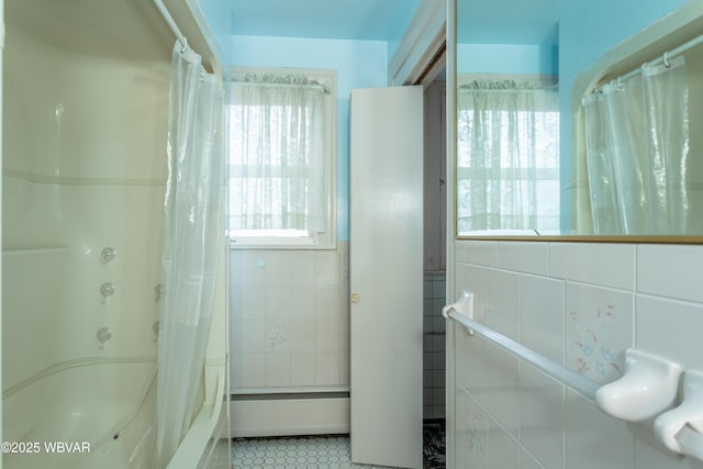 bathroom with plenty of natural light, shower / tub combo, and tile walls