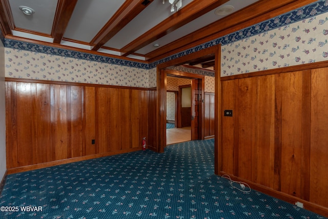 spare room with crown molding and dark colored carpet