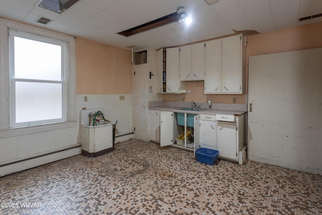 kitchen featuring sink, a baseboard radiator, and white cabinets